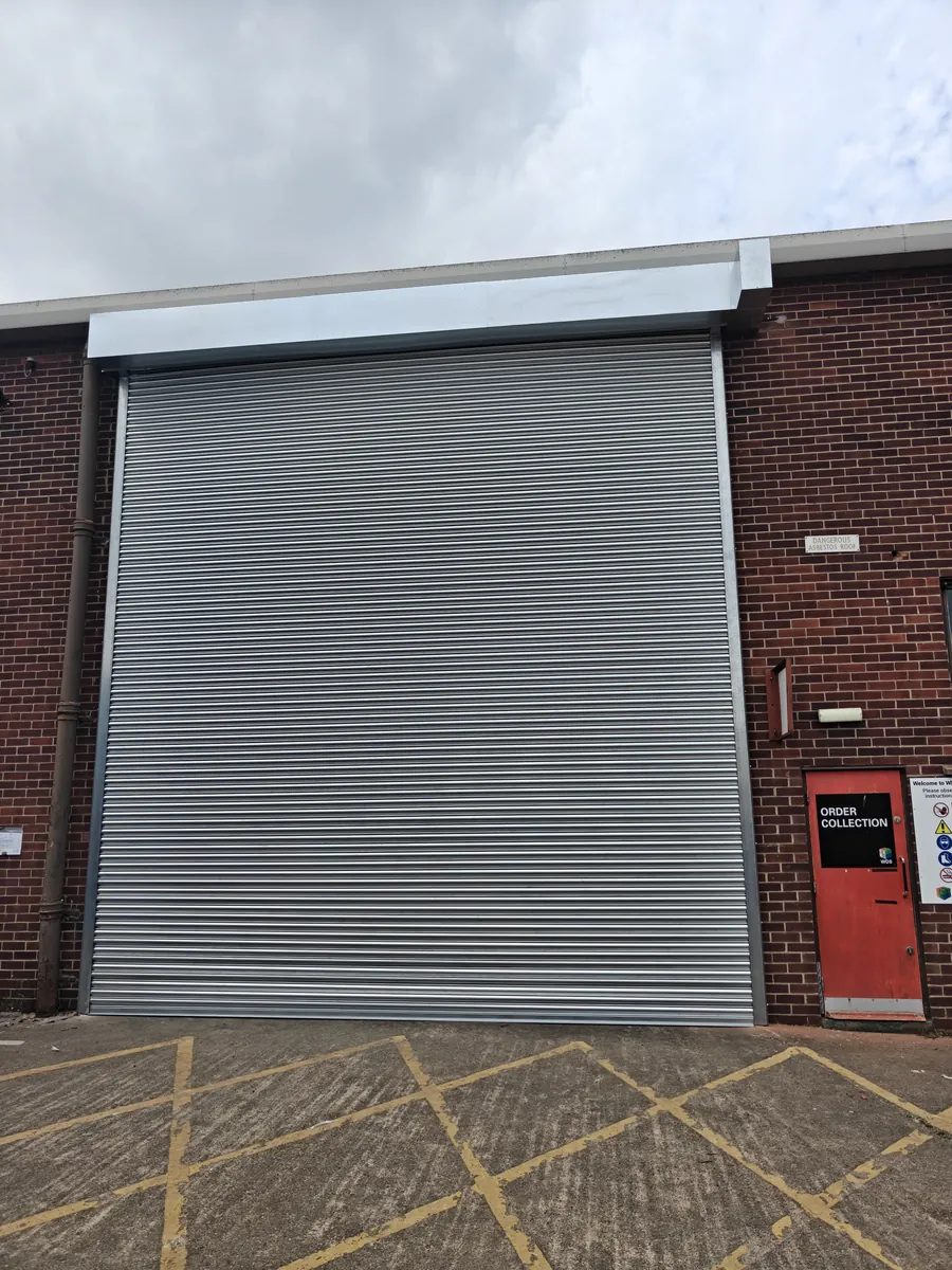 A large roller shutter on a brick industrial building